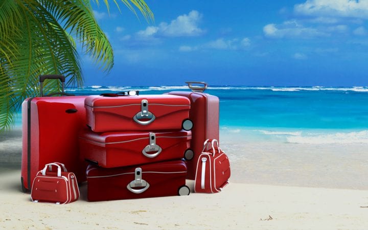 Pile of  red baggage on a tropical beach